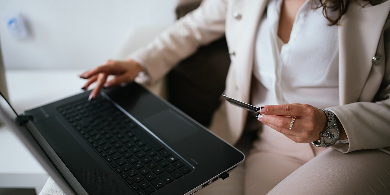 Professional making an online payment with a card and laptop