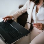 Professional making an online payment with a card and laptop