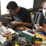 Two technicians working together on a laptop