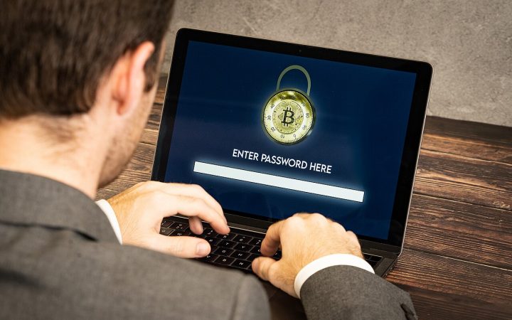 Person entering a password on a laptop showing a security lock screen
