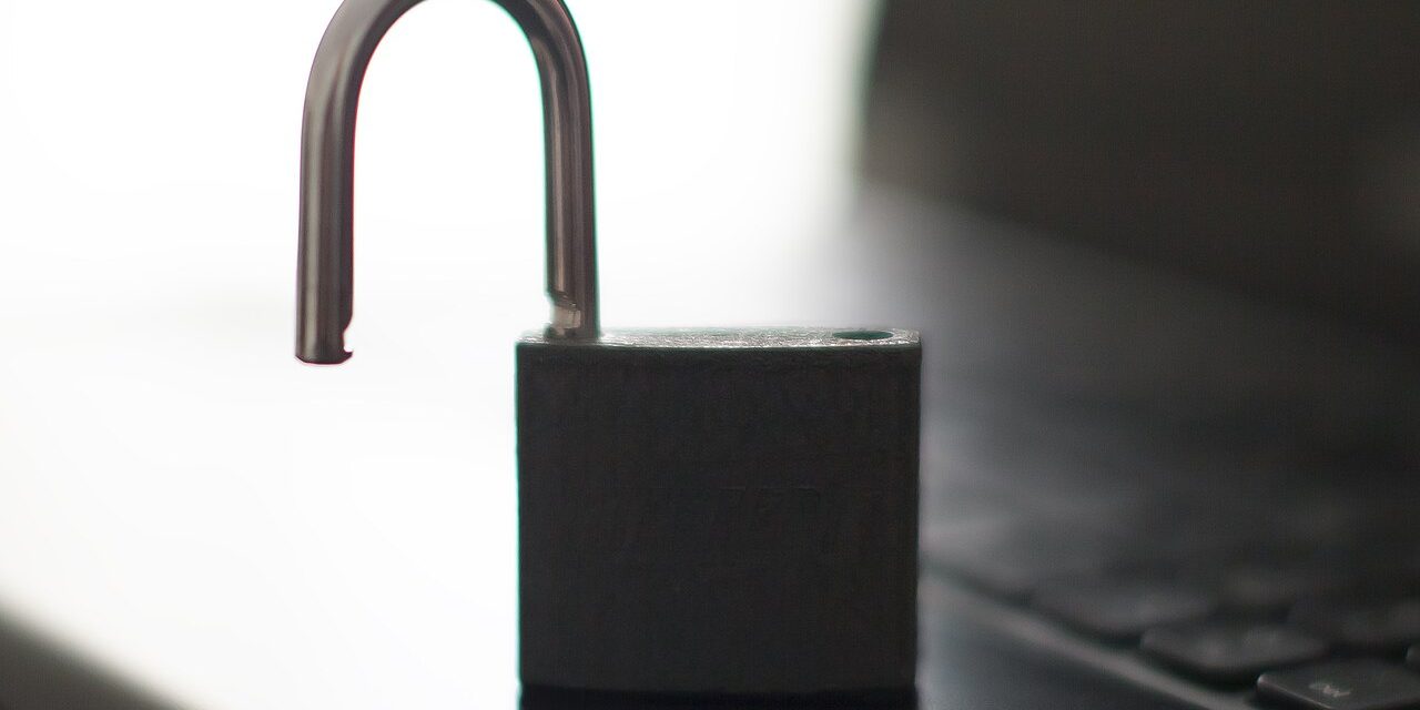 Open padlock resting on a laptop keyboard
