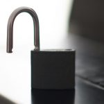 Open padlock resting on a laptop keyboard