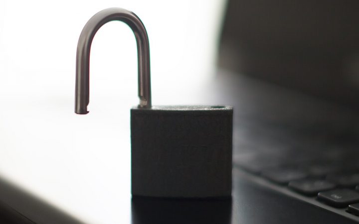 Open padlock resting on a laptop keyboard