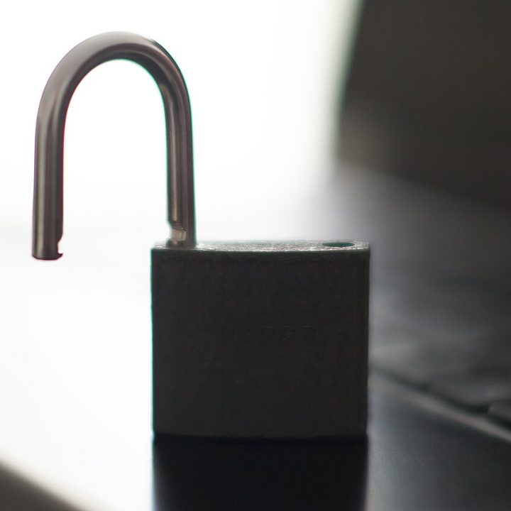Open padlock resting on a laptop keyboard