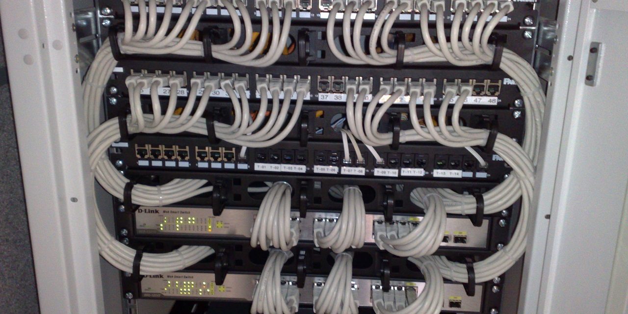 Rack-mounted Ethernet switches and patch panels being reviewed