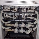 Rack-mounted Ethernet switches and patch panels being reviewed